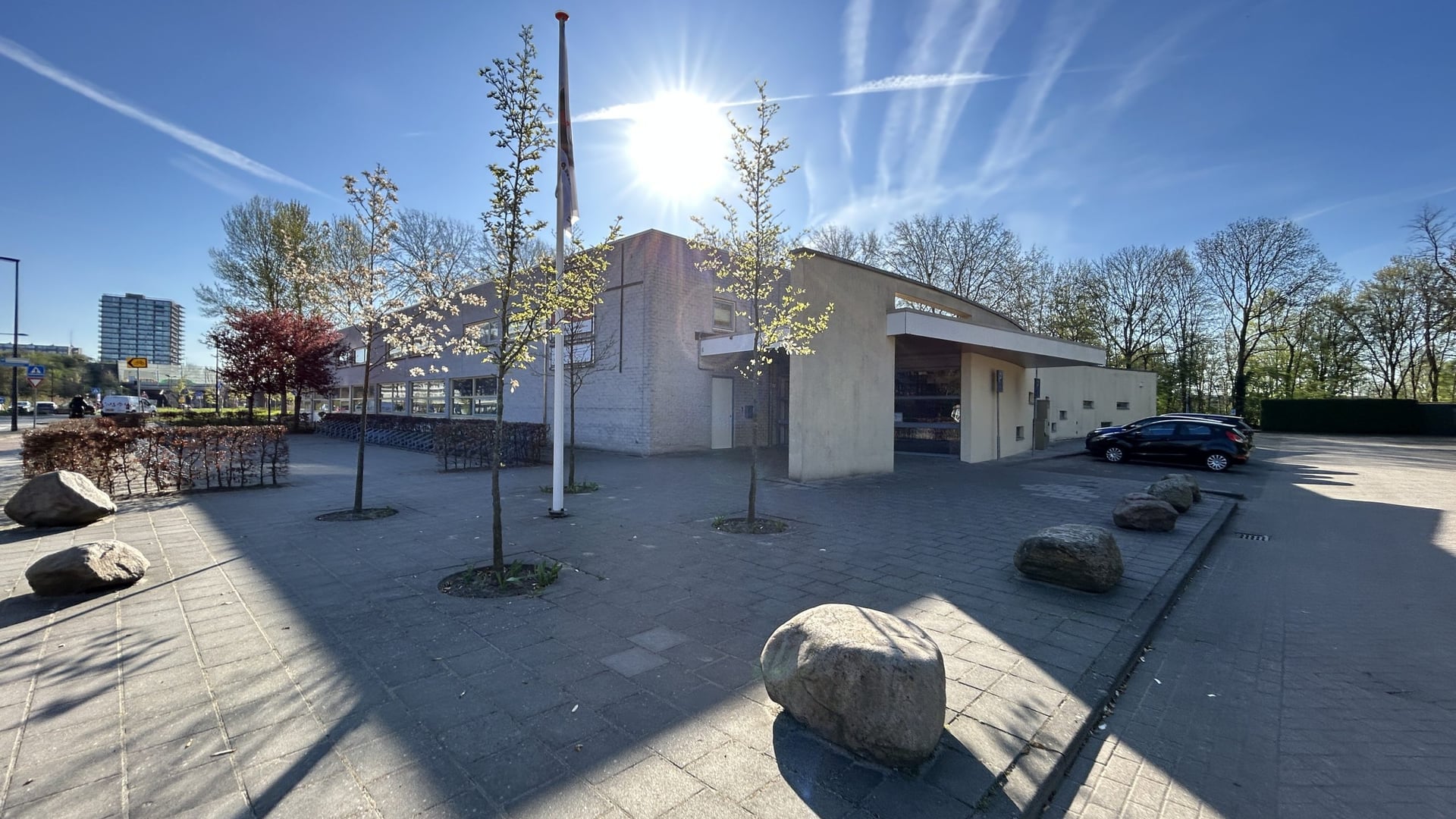 Het gebouw van Z1 Verhuur aan de Zwanensingel in Vlaardingen, met bloeiende bomen en de eigen parkeerplaats